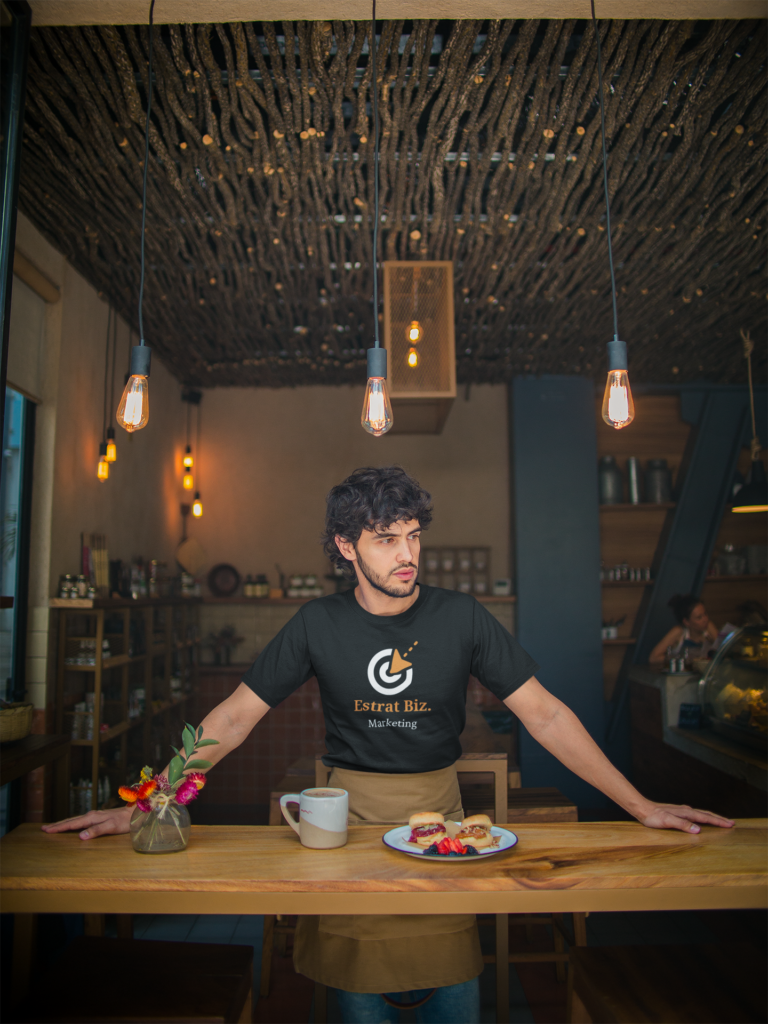 mockup-of-a-waiter-wearing-a-t-shirt-leaning-against-a-wooden-table-a20480 (2)